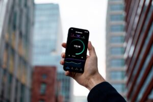 Hand holding a phone with a health tracking app between city buildings