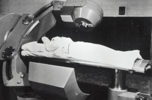 Vintage radiotherapy machine with a patient, black and white