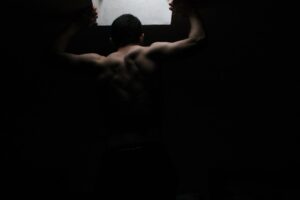Man silhouetted against a bright screen in the dark