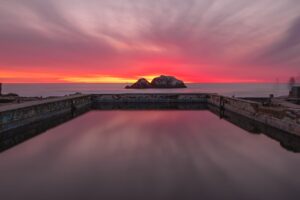 Red sunrise over a calm infinity pool