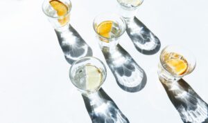Glasses of citrus-infused water casting long shadows