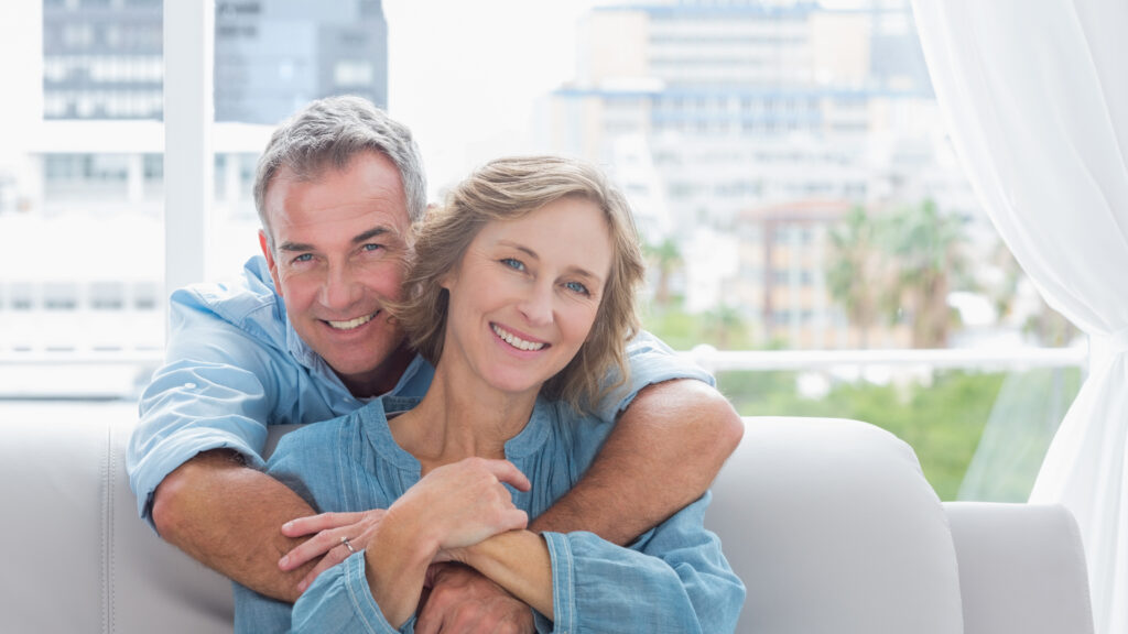 Smiling mature couple embracing on a sofa