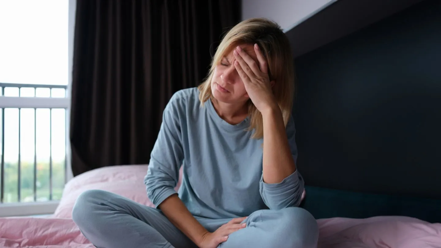 Tired Woman Sitting On The Edge Of Bed
